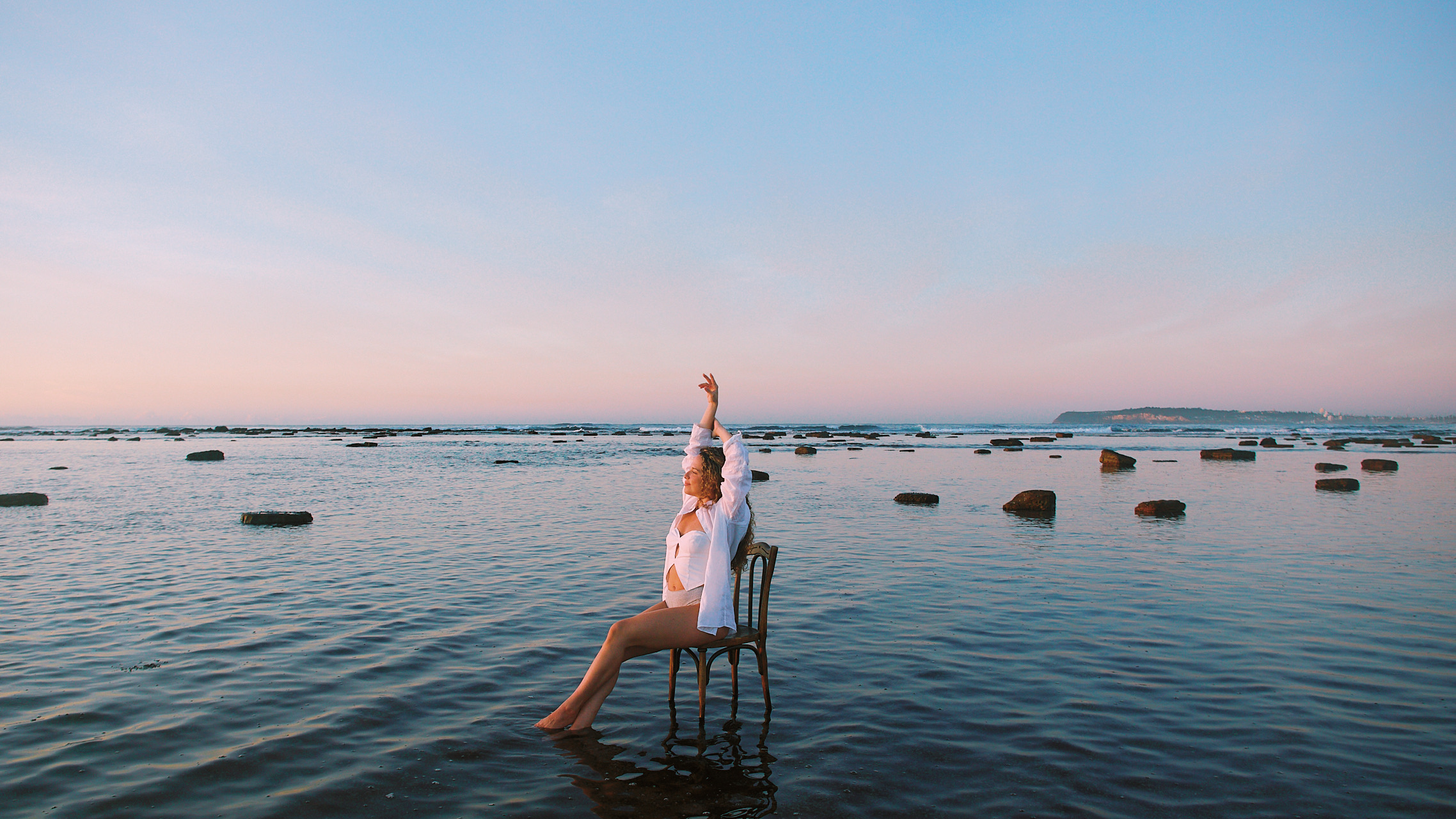 Healing therapist sitting in the shallows of the sea at sunrise – personal branding photography by MelCreative